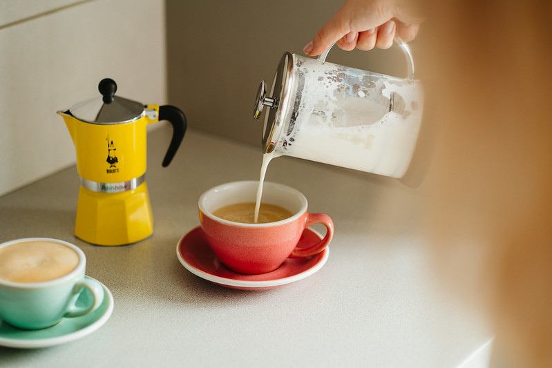 pouring milk into the moka pot coffee